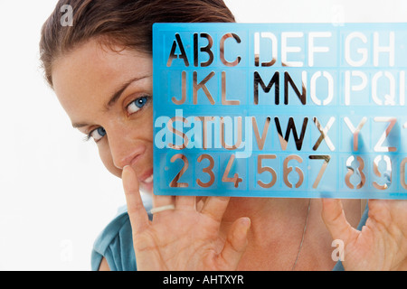 Close-Up portrait of woman through window using graphic drawing equipment. Stock Photo