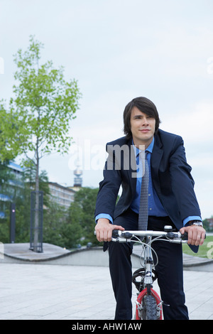 Businessman on bike laughing. Stock Photo
