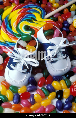 Baby shoes with large sucker and jelly beans Stock Photo