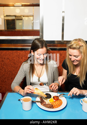 Two young women sharing a meal in a diner Stock Photo