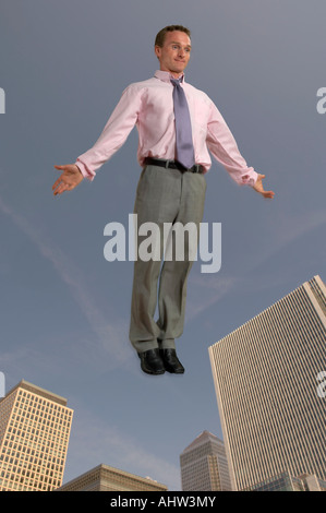 Businessman in the air with city in the background Stock Photo