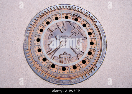 Horizontal close up of a decorative circular man hole cover in the streets of Berlin, cast with the major prominent landmarks. Stock Photo