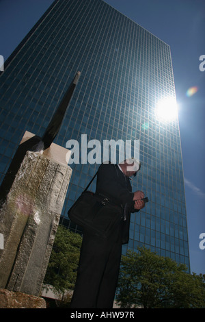The man manager standing in front of an office building on the city street with PDA Personal Data Assistant in USA US vertical hi-res Stock Photo