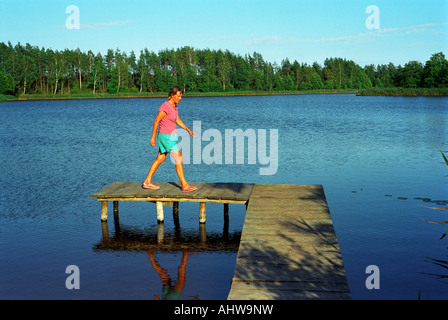 Woman walking on a jetty, Suwalki, Poland Stock Photo