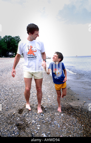Father and son in a pensive moment at the water s edge Stock Photo