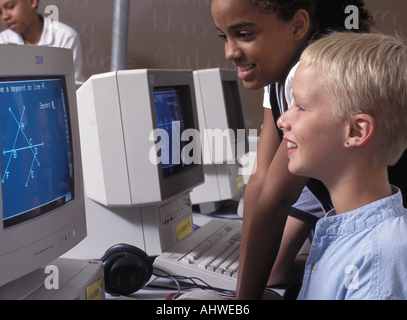 Caucasian and African American students using computer in middle school class Stock Photo