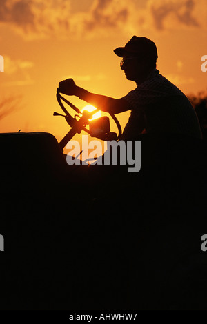 Farmer silhouetted by early morning sun Stock Photo