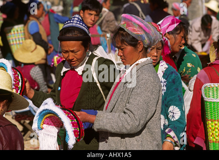 China Yunnan Shaping market women buying Bai head dress symbolising the four natural elements of air earth fire water Stock Photo