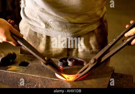 Re Change of career to take up rural crafts Fire welding a sea scroll during his training to be a blacksmith at The Hereford C Stock Photo