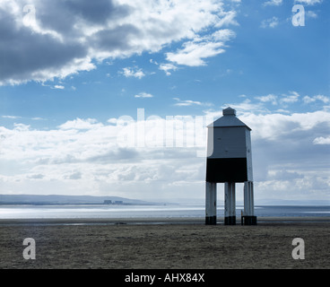 The wooden lighthouse on stilts on the beach at Burnham-on-Sea in Somerset, England. Across Bridgwater Bay can be seen the structures of Hinkley Point power station. Stock Photo