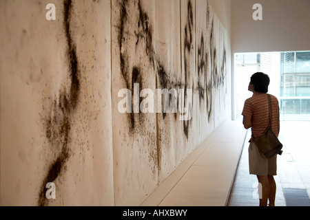 Woman in silhouette looking at artwork in interior of Gallery of Modern Art Brisbane Queensland QLD Australia Stock Photo