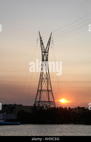 Electricity power transmission lines pylon over river in evening summer sunlight Brisbane Queensland QLD Australia Stock Photo