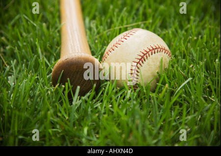 Bat and baseball laying on grass Stock Photo