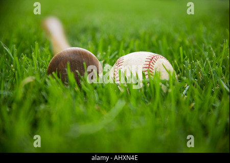 Bat and baseball laying on grass Stock Photo