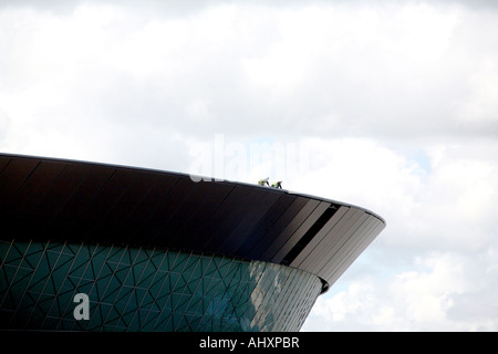 Two construction workers on roof of giant new arena and convention centre in Liverpool Stock Photo