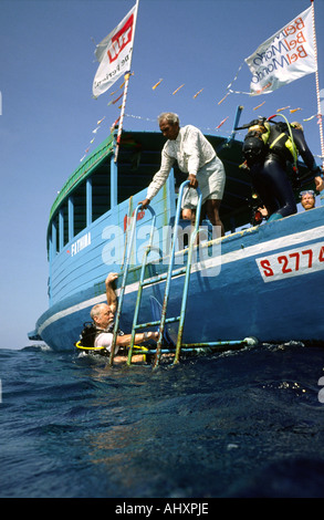 Maldives Kuredhu resort diver returning to dhoni Stock Photo