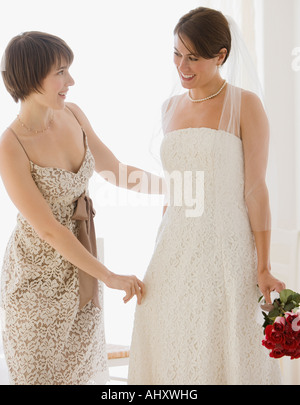 Bridesmaid adjusting bride’s veil Stock Photo