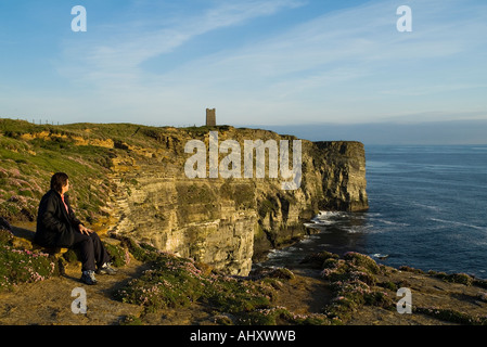 dh Marwick Head BIRSAY ORKNEY Seacliff Woman tourist RSPB Bird Nature reserve Kitchener Memorial on cliff top looking out sea one teen girl uk alone