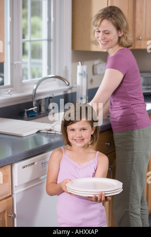 Mother and daughter washing dishes Stock Photo