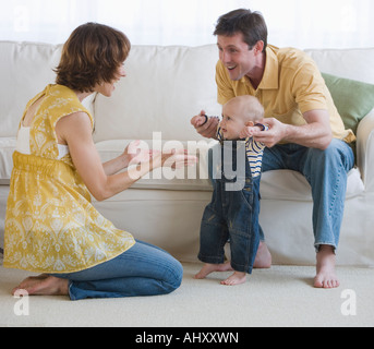 Parents helping baby walk Stock Photo