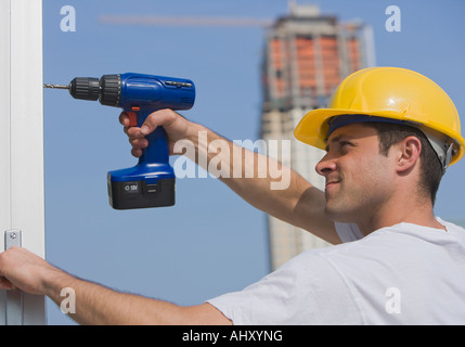 Construction worker using cordless drill Stock Photo