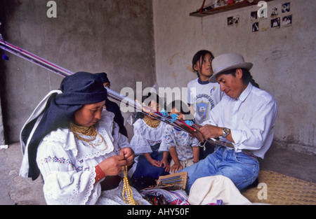 Otavalo Indian weaver, using Backstrap Loom, and his family, Ecuador Stock Photo