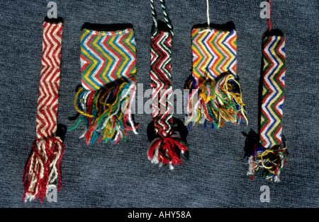 Handcrafted Wirstlebands created by Tibetan prisoners in Tibet, featuring colorful zigzag patterns and decorative tassels on a dark background. Stock Photo