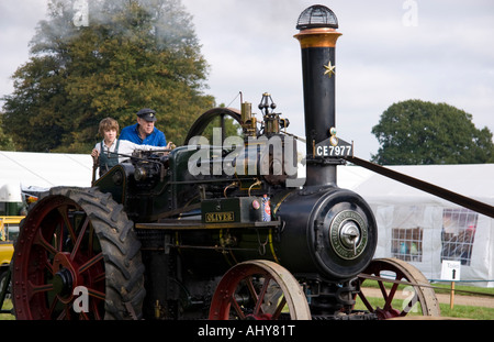 Elderly man and young boy operating a steam traction engine Stock Photo