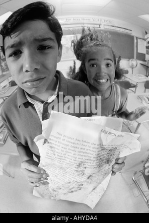 Two Latino middle school students with messy homework papers Using the ...