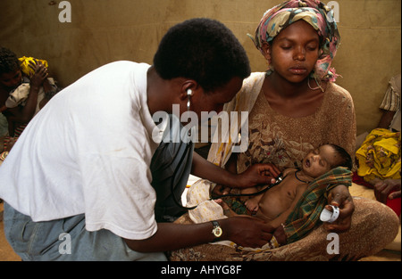 Ethiopian doctor examining a malnourished Somali baby in a refugee camp. Ethiopia Stock Photo
