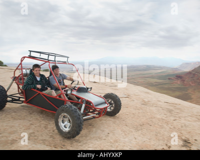 People in off-road vehicle on rock formation Stock Photo