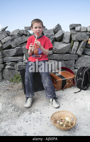 Young boy busking and playing a tin whistle Inishmore, Aran islands Ireland Stock Photo