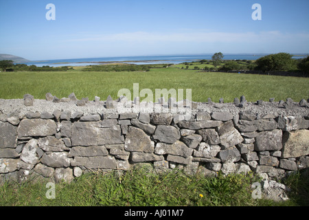 Dry stone wall and field looking out over Galway Bay near Ballyvaughan County Clare Ireland Stock Photo