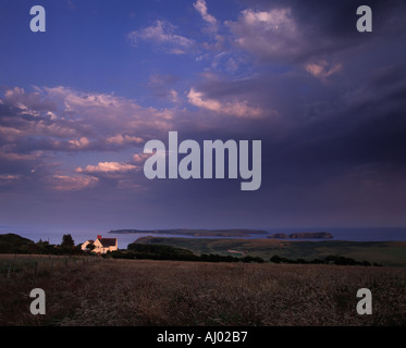 Setting sun across Caldey Island and Giltar point near Tenby Wales Stock Photo