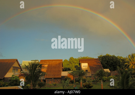 Rainbow over traditional style housing, Mauritius Stock Photo