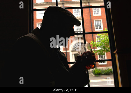 Old man drinking pint of beer in pub UK Stock Photo