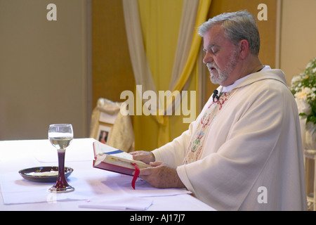 Catholic Priest administers wedding vows and prayers at St Thomas Catholic Church in Ojai California Stock Photo