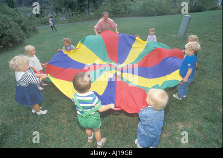 Daycare children playing a parachute game Stock Photo