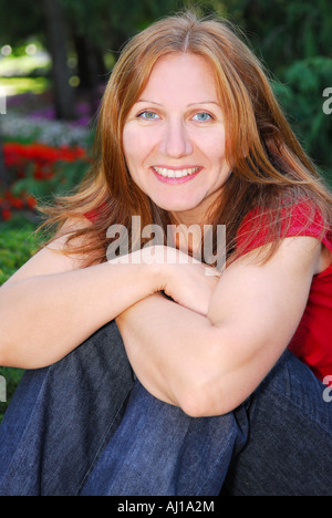 Portrait of smiling attractive mature woman relaxing in summer park Stock Photo