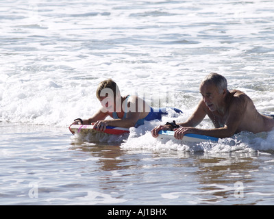 old couple body boarding Stock Photo