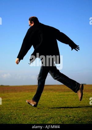 A man running in black coat Stock Photo