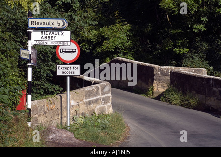 The ancient medieval Rievaulx Bridge of the River Rye with signs pointing (contd.) Stock Photo