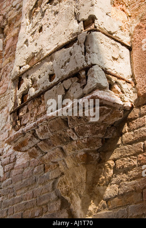 Weathered old brick at base of chimney attached to brick wall of residential building in the Dorsoduro district of Venice Italy Stock Photo