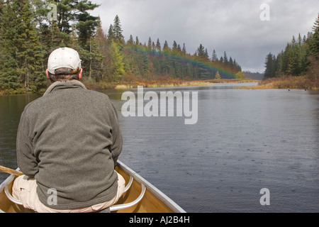 Canoe on Rain Lake with rainbow in Algonquin Provincial Park Stock Photo