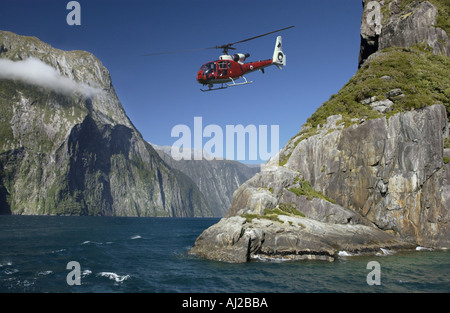 Helicopter flying over Milford Sound on the south island of New Zealand Stock Photo
