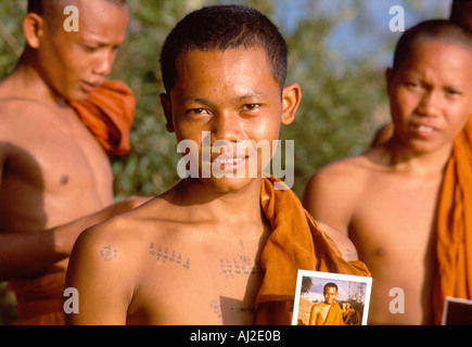 Young monks with souvenir portrait polaroids after an afternoon swim. Sisophon Cambodia. Stock Photo