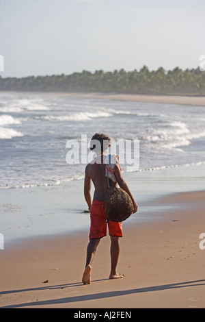 Fisherman returning home along the beach on Atlantic ocean in the Bahia region of the north east of Brazil Stock Photo