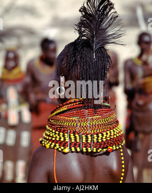 A Turkana woman with braided hair wearing heavy beaded necklaces and a black ostrich feather in the typical attire of Turkana Stock Photo