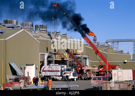 USA Alaska Prudhoe Bay Gas flare and black smoke billow above work crew at Prudhoe Bay Stock Photo