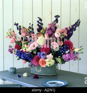 Flower arrangement  in blue pot with white cameo detail on wooden table Stock Photo